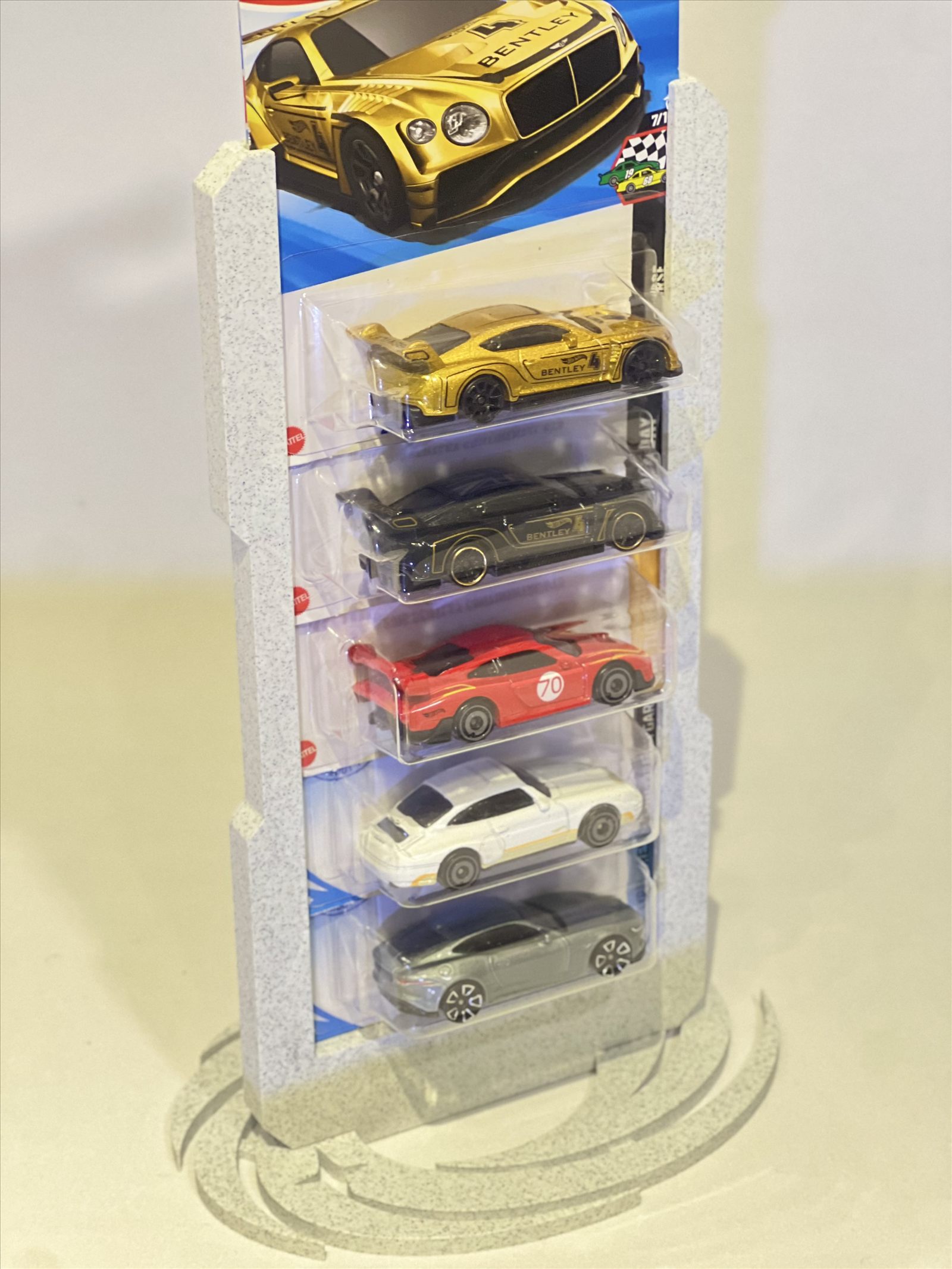 Foto real do display Apex branco marmorizado carregado com cinco embalagens blister de miniaturas