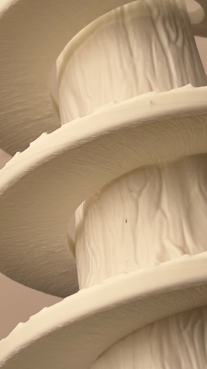 Foto real do protótipo do Tree v0.1 — detalhe dos discos em espiral e da textura do tronco impresso em PLA branco
